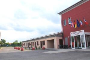 un bâtiment rouge avec des drapeaux sur son côté dans l'établissement Hotel Motel Giglio, à Viadana