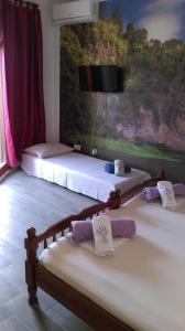 dwa łóżka w pokoju z telewizorem na ścianie w obiekcie Guest House Marija w mieście Sumartin
