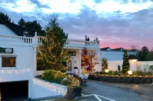 una casa blanca con árboles de navidad y luces en Hotel Ramor Garni, en Duisburg