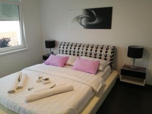 a bedroom with a large bed with pink pillows at Apartment Andro in Dramalj