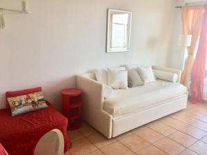 a living room with a white couch and a red table at Mandelieu centre -Les Hauts de Lérins in Mandelieu-la-Napoule +38 photos