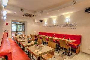 a restaurant with wooden tables and red booths at Hotel Franklin Feel The Sound in Rome