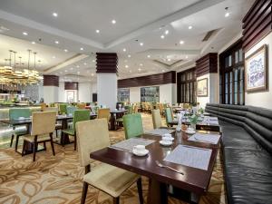 a dining room with tables and chairs in a restaurant at Royal Halong Hotel in Ha Long