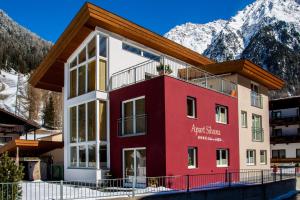 a building with mountains in the background at Apart Silvana in Längenfeld