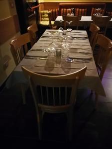 uma longa mesa com copos de vinho em cima em Manouche Osteria B&B em Caserta