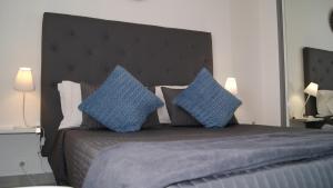 a bedroom with a large bed with blue pillows at Residence Bellavista à Santa Giulia, proche de la plage et vue mer in Porto-Vecchio
