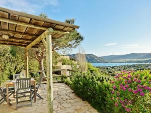 a patio with a table and chairs and flowers at Residence Bellavista à Santa Giulia, proche de la plage et vue mer in Porto-Vecchio