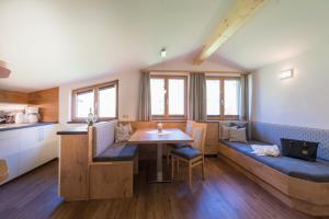 ein Zimmer mit einem Tisch und Bänken in einer Küche in der Unterkunft KENDLGUT Appartements am BioBauernhof inklusive unbegrenztem Eintritt in die Alpentherme in Bad Hofgastein