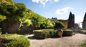 um jardim com arbustos e um edifício e uma casa em San Martinello em Perugia