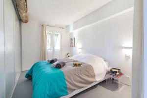 a white bedroom with a bed with a blue blanket at ROSS 5- F2, LUMINEUX, BALCON, LOFT, CLIM, Vieux-Nice in Nice
