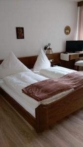 a large bed in a bedroom with a desk at Hotel-Restaurant Jägerhof in Unterreichenbach