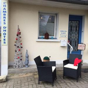 een kerstboom en stoelen voor een huis bij chambres de la Nonette in Senlis