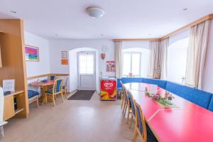a classroom with a red table and chairs and a desk at Gästehaus Ulrichsberg in Ulrichsberg