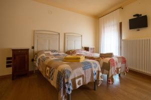 a bedroom with two beds and a tv on the wall at B&B da Toi in Marostica