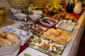 ein Buffet mit Speisen auf einem Tisch, darunter Brot und Gebäck in der Unterkunft Hotel Royal in Gliwice