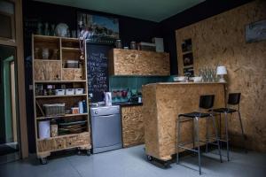 a kitchen with a refrigerator and two bar stools at Hostel Samobor in Samobor