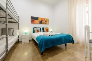 a bedroom with a bed with blue sheets and a bunk bed at Apartamento Tebaida in Granada