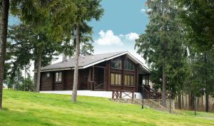 a log cabin in a field with trees at Park Hotel Tseleyevo in Tseleyevo