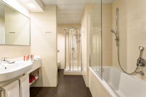 a bathroom with a shower, sink, and mirror at iQ Hotel Roma in Rome