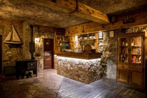 un bar en una habitación con una pared de piedra en Hotel Crnogorska Kuća en Podgorica