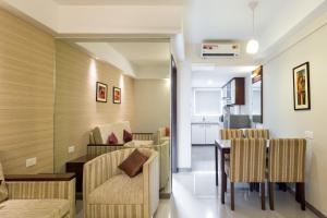 a living room with a table and chairs and a kitchen at D Homz Suites in Cochin