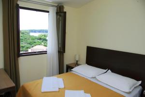 a bedroom with a bed with two pillows and a window at Hotel Priscapac Resort & Apartments in Prizba