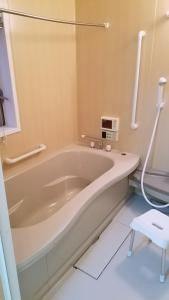 a bath tub in a bathroom with a sink at Villa M Guesthouse in Kanazawa