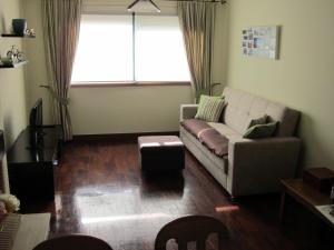 uma sala de estar com um sofá e uma janela em Comfortable & central apartment em Senhora da Hora