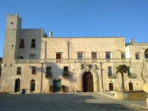 un gran edificio de ladrillo con una puerta grande y un balcón en B&B Verardo, en Specchia