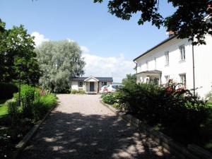 a driveway leading to a white house with a car at Tössestugan in Tösse