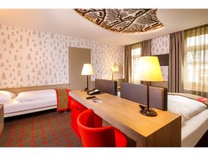 a hotel room with a desk and a bed at Swiss Night by Fassbind in Zurich