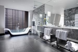 a bathroom with a tub and a sink and a bath tub at South Place Hotel in London