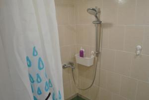 a shower with a shower curtain in a bathroom at Apartments Vavilon 4 in Yekaterinburg