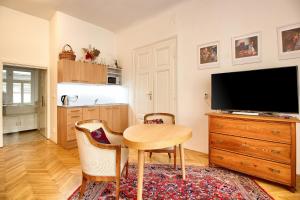 uma sala de estar com uma mesa e uma televisão em At the Three Princes em Brno