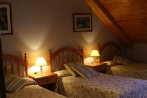 a bedroom with two beds and two lamps on tables at Casa Raspa in Bielsa