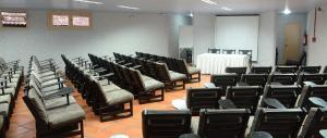 a room with rows of chairs and a table at San Willa's Hotel in São Miguel dʼOeste +46 photos