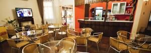 a restaurant with tables and chairs and a bar at San Willa's Hotel in São Miguel dʼOeste