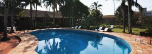 een zwembad in een tuin met stoelen en bomen bij San Willa's Hotel in São Miguel dʼOeste