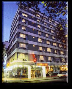 een hoog gebouw in een stadsstraat met een verkeerslicht bij Hotel Klee in Montevideo