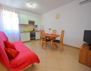 a kitchen and dining room with a table and chairs at Apartments Ivanka in Malinska