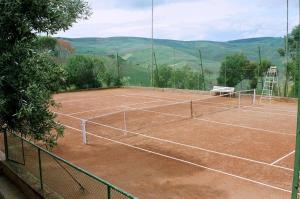 a tennis court with a net on top of it at Hotel Moulay Yacoub in Moulay Yacoub