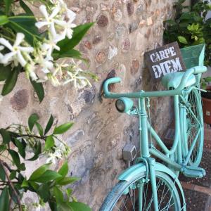 una bicicletta blu è attaccata a un muro di pietra di Bed & Breakfast Carpe Diem a Solferino