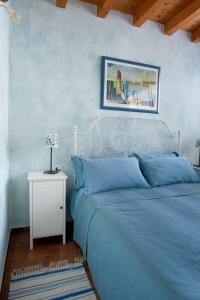 una camera con un letto blu e una foto sul muro di Bed & Breakfast Carpe Diem a Solferino