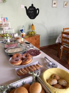 una tavola con piatti di ciambelle e altri alimenti di Bed & Breakfast Carpe Diem a Solferino