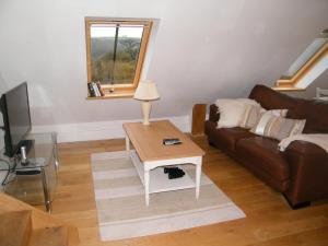 ein Wohnzimmer mit einem Sofa und einem Tisch in der Unterkunft Higher Greenway Annexe in Brixham