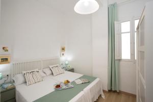 バレンシアにあるAntiguo Reino Apartmentの白いベッドルーム(大きな白いベッド1台、窓付)