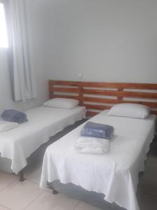 dos camas sentadas una al lado de la otra en una habitación en Flat Econômico Uberlândia, en Uberlândia