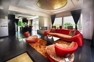 a living room with a red couch and red chairs at Villa Valerio in Poreč