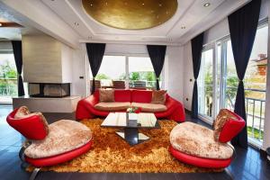 a living room with a red couch and chairs at Villa Valerio in Poreč