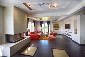 a living room with a fireplace and red furniture at Villa Valerio in Poreč
